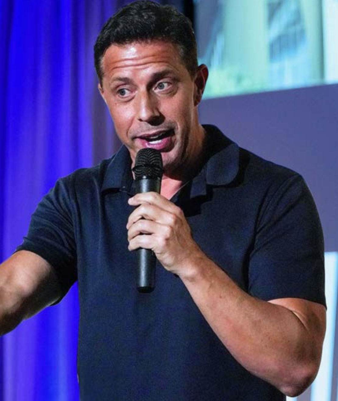 Aaron Bare speaking at a microphone